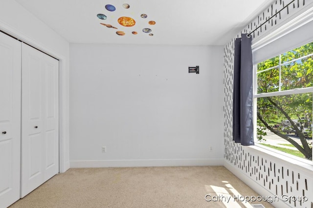 950 Whitetail Ct, Ionia, MI 48846 - unfurnished bedroom with multiple windows, light carpet, and a closet