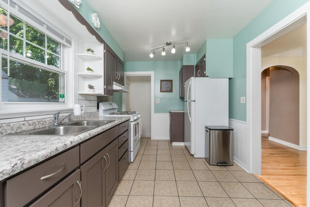 1608 Cambridge Dr, Kalamazoo, MI 49001 - kitchen featuring white appliances, under cabinet range hood, open shelves, light countertops, and arched walkways