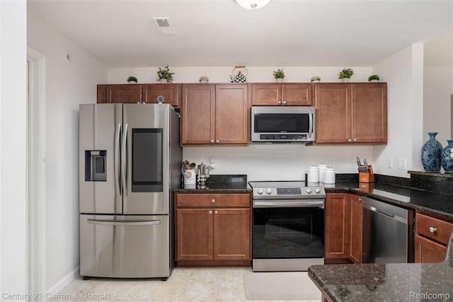 29611 Fox Run Cir, Warren, MI 48092 - kitchen with appliances with stainless steel finishes, dark stone counters, brown cabinets, and light tile patterned flooring