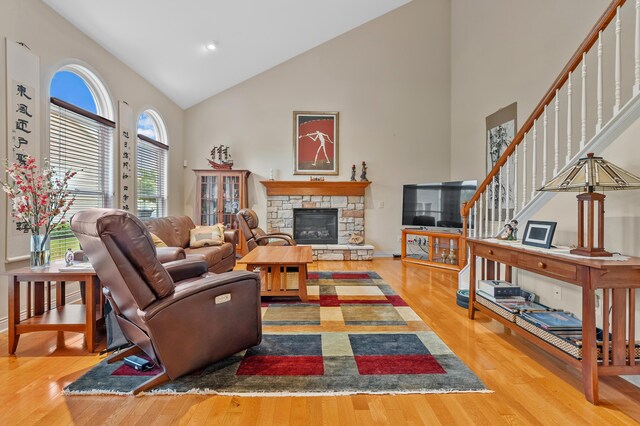 6380 Mcgillicuddy Ln, Portage, MI 49024 - living room featuring high vaulted ceiling, wood finished floors, stairway, and a stone fireplace