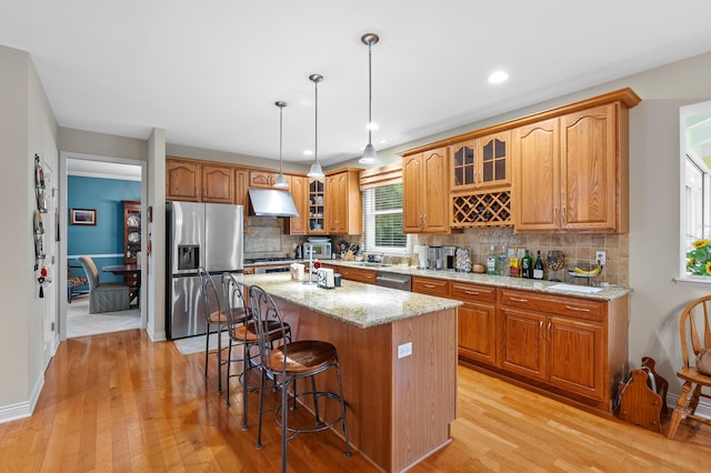 6380 Mcgillicuddy Ln, Portage, MI 49024 - kitchen featuring stainless steel appliances, under cabinet range hood, light wood-style floors, a kitchen bar, and recessed lighting