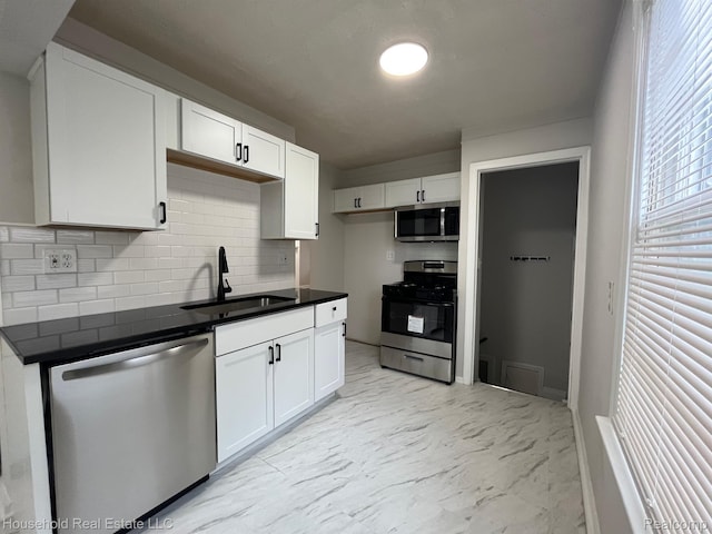 14722 Lydia Ave, Eastpointe, MI 48021 - kitchen featuring stainless steel appliances, dark countertops, tasteful backsplash, and white cabinetry