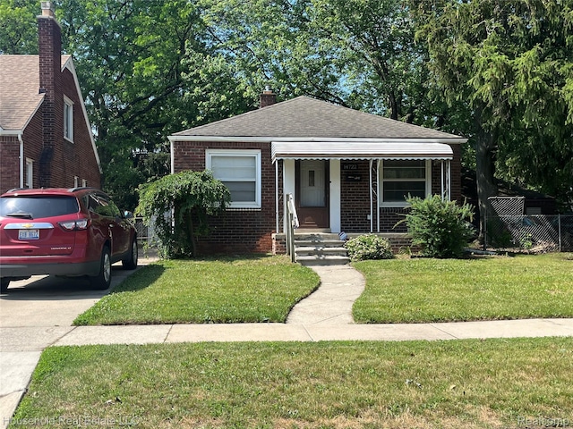 14722 Lydia Ave, Eastpointe, MI 48021 - bungalow with brick siding, a porch, a shingled roof, and a chimney