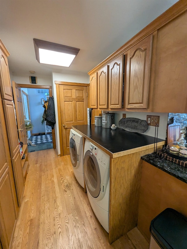 2740 Booth Rd, Au Gres, MI 48703 - laundry room featuring washer and dryer, light wood-style floors, and cabinet space