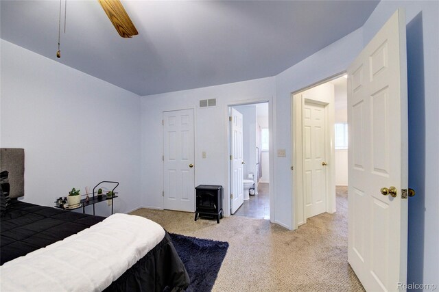 6397 Hunter Pointe St, Westland, MI 48185 - bedroom with a wood stove, light carpet, ensuite bath, and ceiling fan