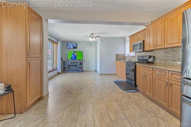 3901 Westpoint St, Dearborn Heights, MI 48125 - kitchen with appliances with stainless steel finishes, light stone countertops, a ceiling fan, and decorative backsplash
