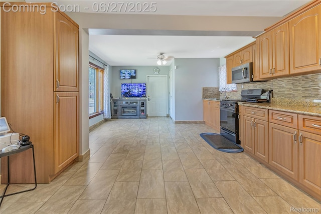 3901 Westpoint St, Dearborn Heights, MI 48125 - kitchen with black range with gas cooktop, stainless steel microwave, light stone countertops, tasteful backsplash, and a ceiling fan
