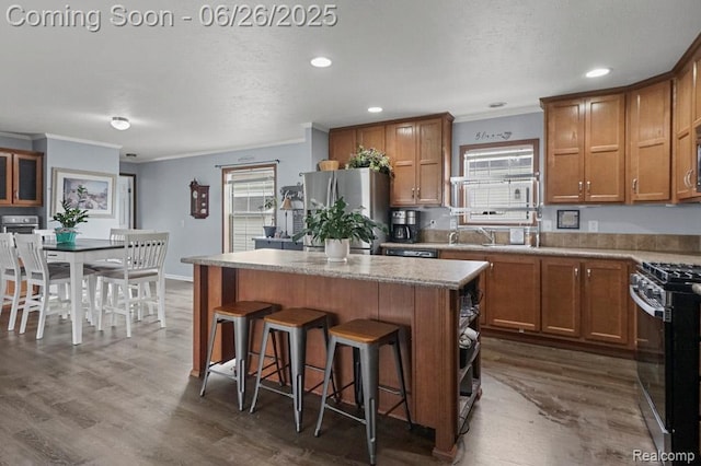 26317 Cherokee E, Flat Rock, MI 48134 - kitchen with stainless steel appliances, a center island, crown molding, a breakfast bar, and dark wood-style flooring
