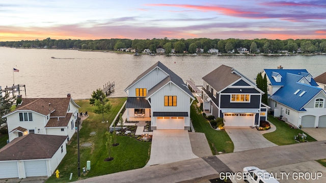 1351 Bayview Dr, Holland, MI 49423 - view of front facade featuring driveway, a water view, board and batten siding, and a front lawn