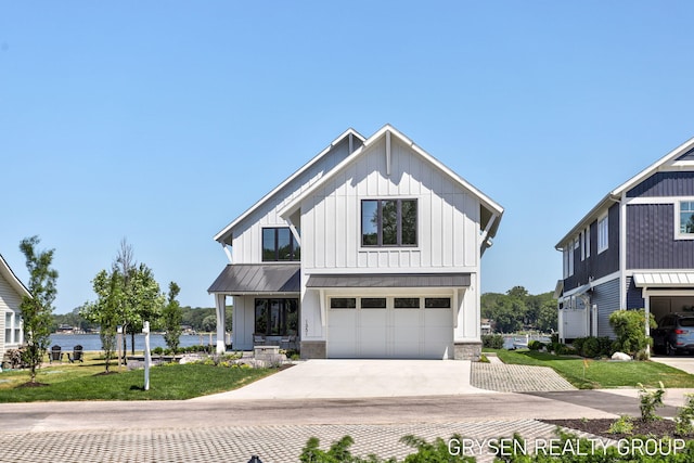 1351 Bayview Dr, Holland, MI 49423 - modern farmhouse style home featuring a standing seam roof, board and batten siding, driveway, a garage, and a water view