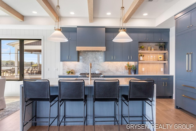 1351 Bayview Dr, Holland, MI 49423 - kitchen with wall chimney range hood, beamed ceiling, tasteful backsplash, light wood-style flooring, and pendant lighting