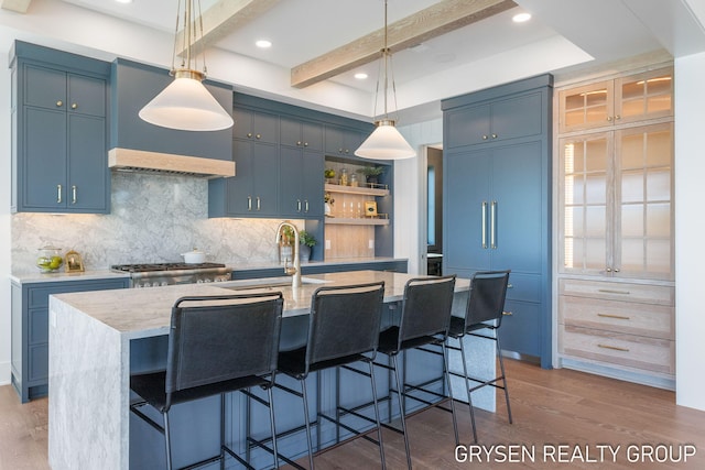 1351 Bayview Dr, Holland, MI 49423 - kitchen featuring decorative backsplash, blue cabinetry, wood finished floors, light stone counters, and recessed lighting