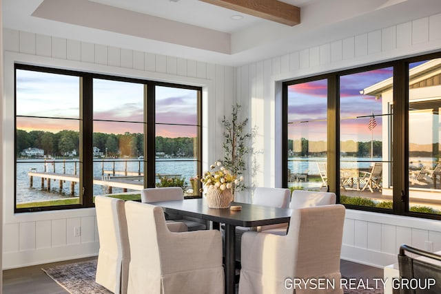 1351 Bayview Dr, Holland, MI 49423 - dining space featuring dark wood-style floors, a water view, and a decorative wall