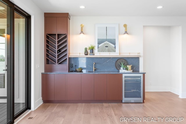 1351 Bayview Dr, Holland, MI 49423 - indoor bar featuring beverage cooler, light wood-style flooring, decorative backsplash, plenty of natural light, and recessed lighting