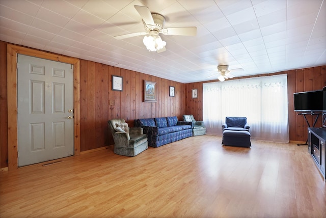 8075 Caine Rd, Millington, MI 48746 - living area with a ceiling fan, light wood finished floors, and wood walls
