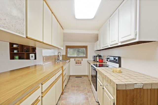 8075 Caine Rd, Millington, MI 48746 - kitchen with white range with electric cooktop, white cabinetry, and stone finish floors