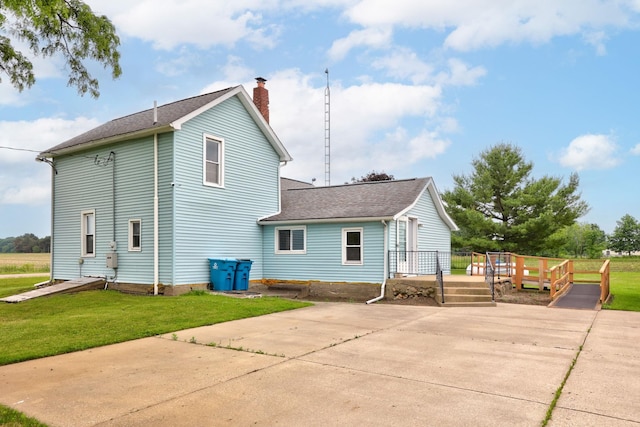 8075 Caine Rd, Millington, MI 48746 - back of property featuring a chimney, a deck, a yard, and roof with shingles