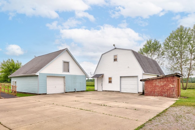 8075 Caine Rd, Millington, MI 48746 - view of home's exterior with a garage, an outbuilding, and roof with shingles