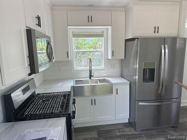 14214 Eastview Dr, Fenton, MI 48430 - kitchen featuring appliances with stainless steel finishes, white cabinetry, and tasteful backsplash