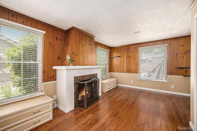 964 W Marshall St, Ferndale, MI 48220 - unfurnished living room with wood walls, a textured ceiling, a fireplace, and wood finished floors