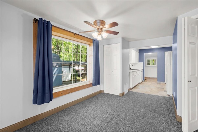 12915 S Englewright Dr, Sand Lake, MI 49343 - spare room featuring light carpet, ceiling fan, and healthy amount of natural light