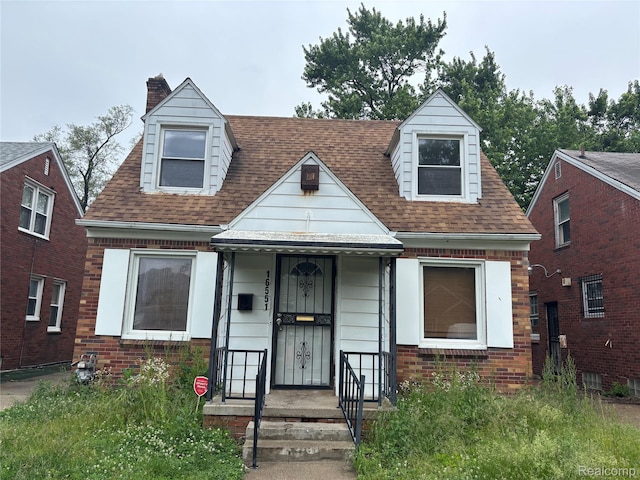 16551 Ardmore St, Detroit, MI 48235 - view of front facade with a chimney, brick siding, and roof with shingles