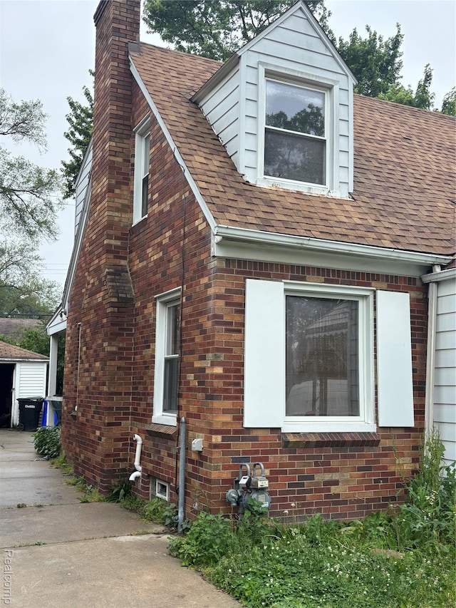 16551 Ardmore St, Detroit, MI 48235 - view of side of property with a chimney, brick siding, and a shingled roof