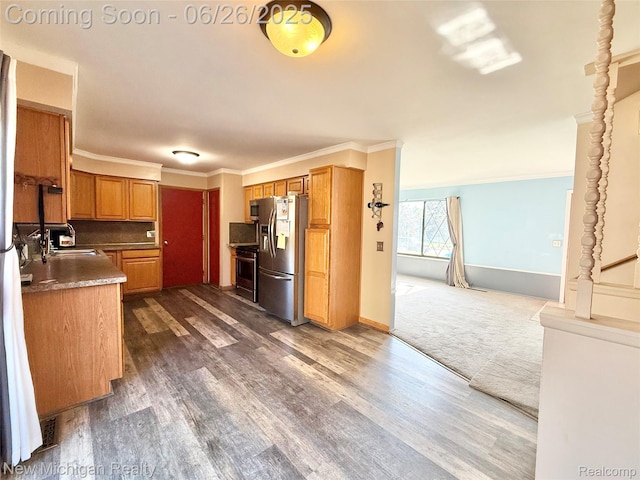 8588 Tim Tam Trl, Flushing, MI 48433 - kitchen with stainless steel fridge, range, dark wood-type flooring, ornamental molding, and brown cabinets