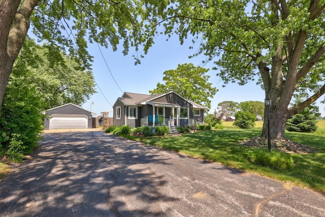 5255 E Holland Rd, Saginaw, MI 48601 - bungalow-style home with an outbuilding, a detached garage, covered porch, and a front yard