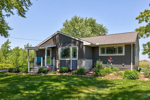 5255 E Holland Rd, Saginaw, MI 48601 - view of front of home with a front lawn, stone siding, and a shingled roof
