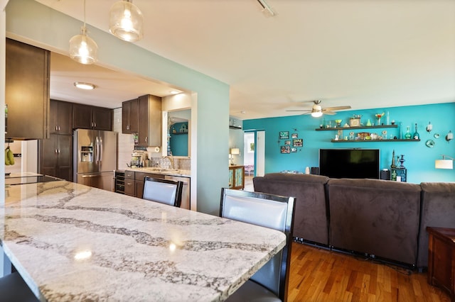5255 E Holland Rd, Saginaw, MI 48601 - kitchen featuring stainless steel fridge, wood finished floors, dark brown cabinetry, a ceiling fan, and light stone counters