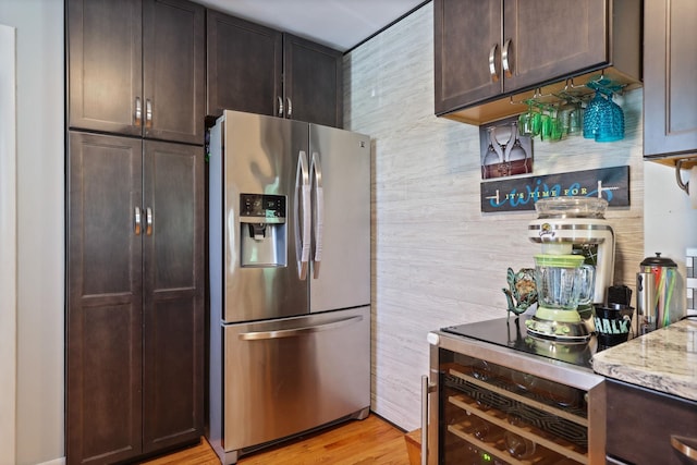 5255 E Holland Rd, Saginaw, MI 48601 - kitchen with stainless steel fridge, dark brown cabinets, light stone counters, and light wood finished floors