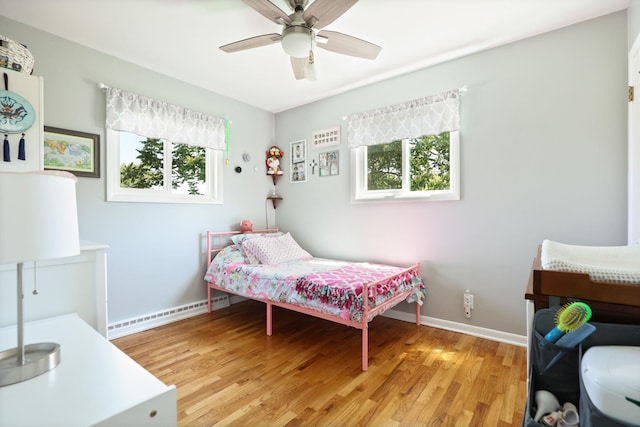 5255 E Holland Rd, Saginaw, MI 48601 - bedroom featuring multiple windows, light wood finished floors, ceiling fan, and a baseboard radiator