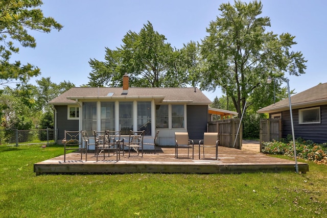 5255 E Holland Rd, Saginaw, MI 48601 - back of property featuring a deck, a sunroom, a chimney, and roof with shingles