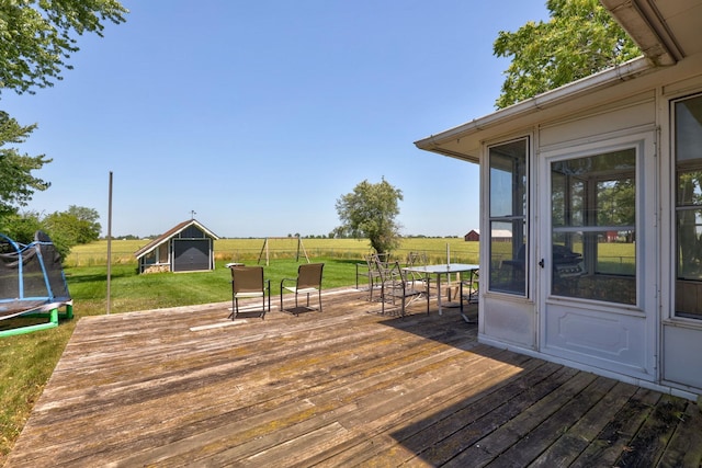 5255 E Holland Rd, Saginaw, MI 48601 - wooden terrace with a trampoline, a lawn, outdoor dining space, and a storage unit