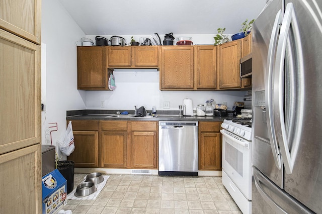 613 Silver Birch St, Howard City, MI 49329 - kitchen with stainless steel appliances, dark countertops, and brown cabinetry