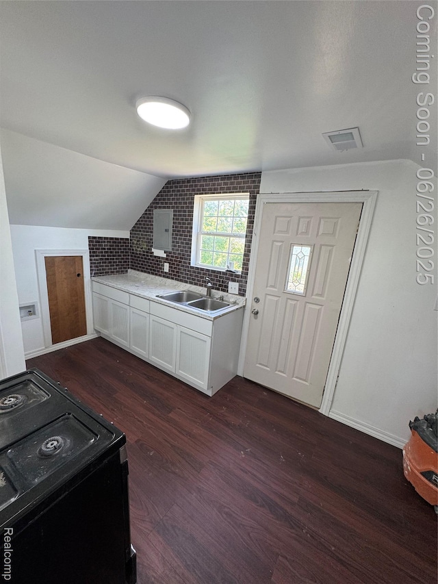 2063 Meade St, Hamtramck, MI 48212 - kitchen with black / electric stove, dark wood-style flooring, vaulted ceiling, white cabinets, and light countertops