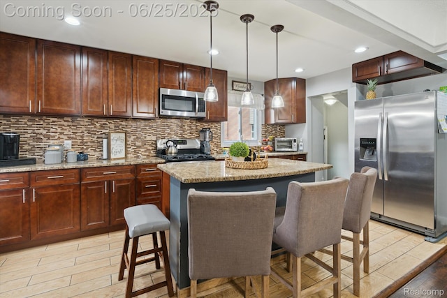 647 Farnham Ave, Lincoln Park, MI 48146 - kitchen with stainless steel appliances, tasteful backsplash, light wood-style flooring, a breakfast bar area, and a center island