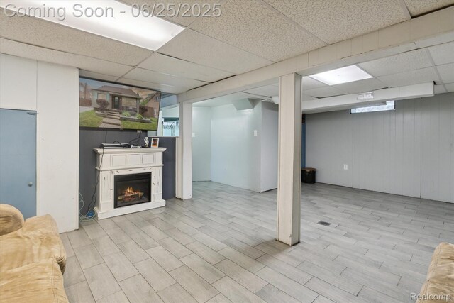 647 Farnham Ave, Lincoln Park, MI 48146 - below grade area with a drop ceiling, a warm lit fireplace, and wood finished floors