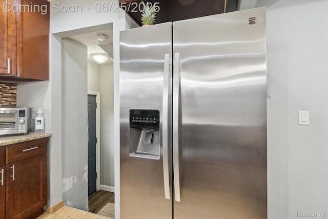647 Farnham Ave, Lincoln Park, MI 48146 - kitchen with stainless steel refrigerator with ice dispenser, light wood-type flooring, and light stone counters