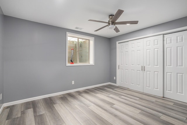 12349 N Sherman Lake Dr, Augusta, MI 49012 - unfurnished bedroom with light wood-type flooring, a closet, and a ceiling fan
