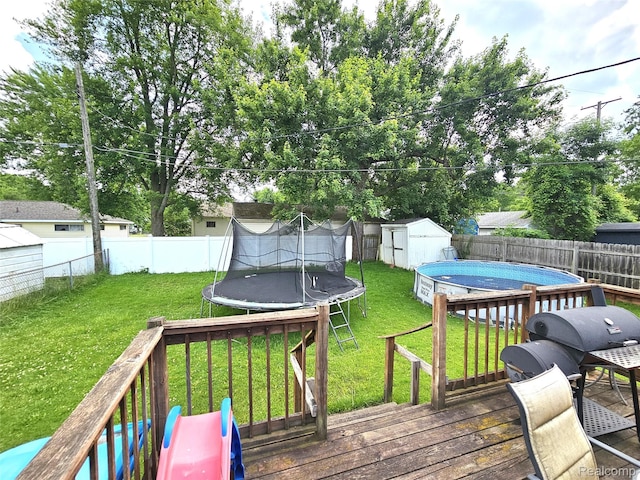356 Spruce St, Mount Morris, MI 48458 - wooden terrace with a trampoline, a shed, and a fenced backyard