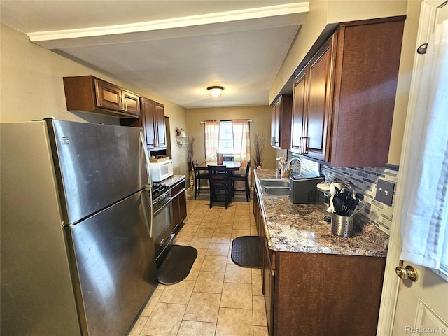 356 Spruce St, Mount Morris, MI 48458 - kitchen with appliances with stainless steel finishes, backsplash, light tile patterned floors, and dark brown cabinetry