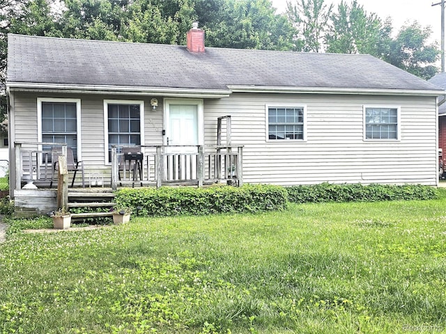 356 Spruce St, Mount Morris, MI 48458 - view of front of house featuring a chimney, a front lawn, a deck, and roof with shingles