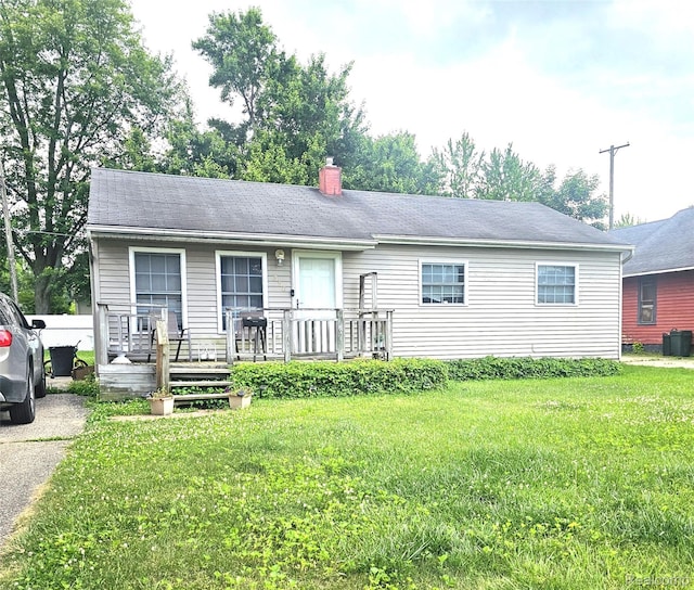 356 Spruce St, Mount Morris, MI 48458 - single story home with a front lawn, a wooden deck, and a chimney