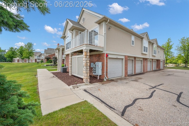21958 Hartford Way, Macomb, MI 48042 - view of side of property with brick siding, a lawn, a balcony, a residential view, and driveway