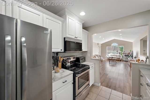 21958 Hartford Way, Macomb, MI 48042 - kitchen featuring appliances with stainless steel finishes, vaulted ceiling, open floor plan, white cabinetry, and light tile patterned floors