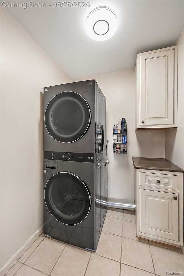 21958 Hartford Way, Macomb, MI 48042 - washroom with stacked washing machine and dryer, cabinet space, and light tile patterned floors