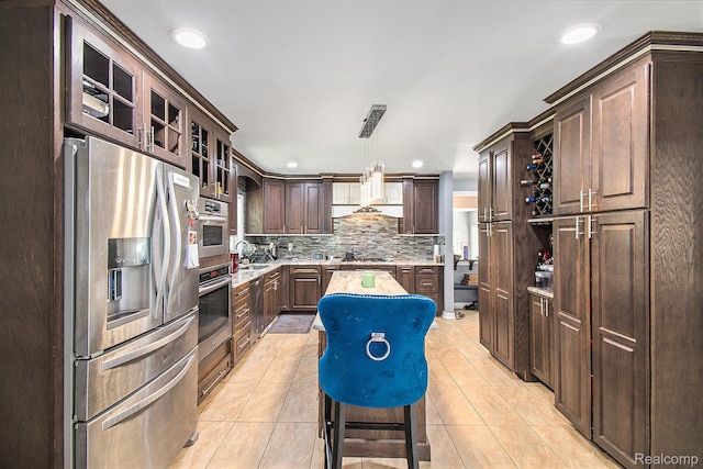 7471 Brewer Rd, Flint, MI 48507 - kitchen featuring appliances with stainless steel finishes, light countertops, dark brown cabinetry, tasteful backsplash, and recessed lighting