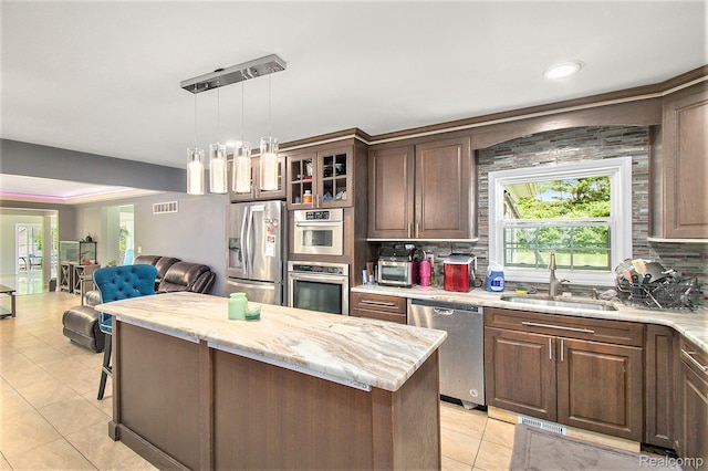 7471 Brewer Rd, Flint, MI 48507 - kitchen with stainless steel appliances, decorative backsplash, light tile patterned flooring, open floor plan, and recessed lighting